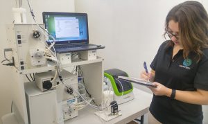 PeCOD Analyzer for chemical oxygen demand analysis at a craft brewery. A female is standing beside the system taking notes.