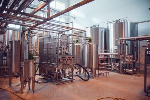 Modern beer plant, with brewing kettles, vessels, tubs and pipes made of stainless steel. Brewery.